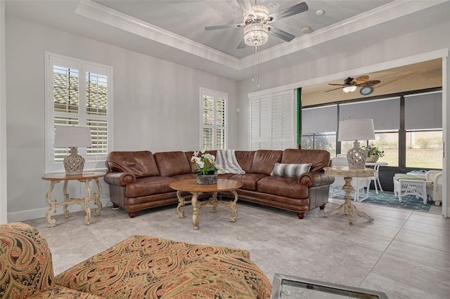 tiled living room featuring a tray ceiling, ceiling fan, and crown molding