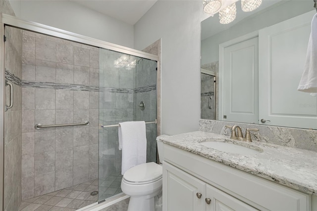 bathroom featuring toilet, a shower with door, and vanity