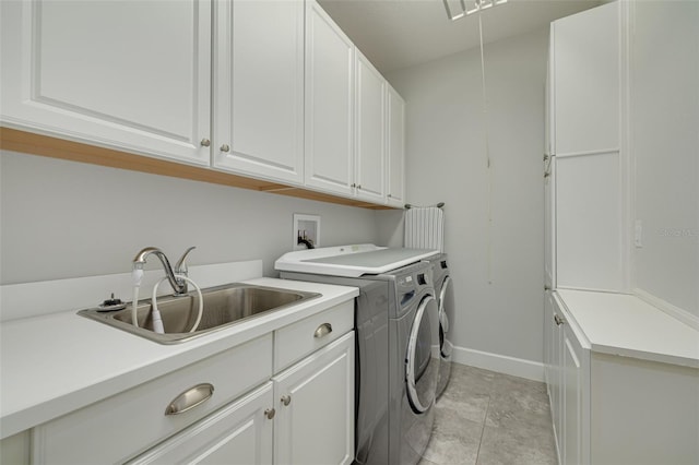 clothes washing area with cabinets, washer and clothes dryer, and sink