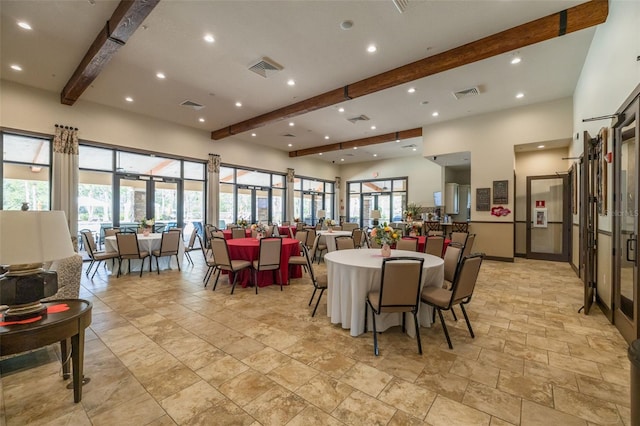 dining space featuring a healthy amount of sunlight and beam ceiling