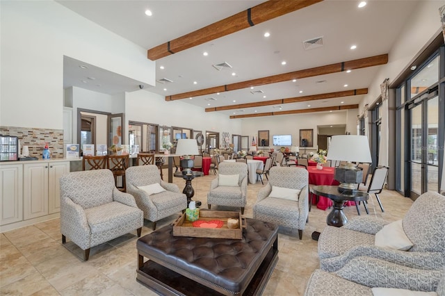living room featuring beam ceiling and a towering ceiling