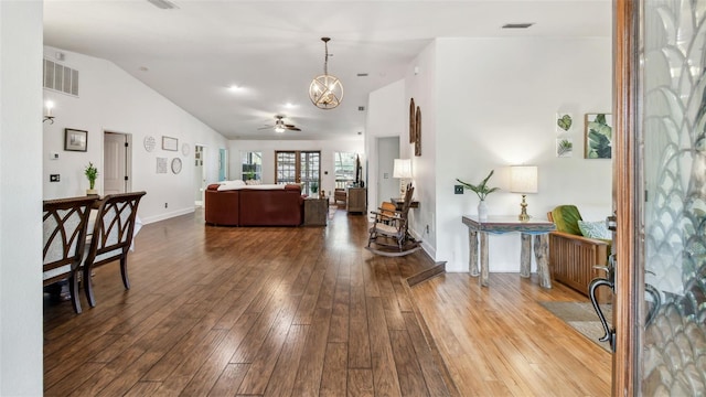 interior space featuring lofted ceiling, ceiling fan with notable chandelier, and wood-type flooring