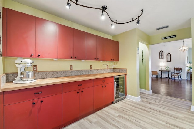 kitchen featuring wine cooler, butcher block counters, and light wood-type flooring