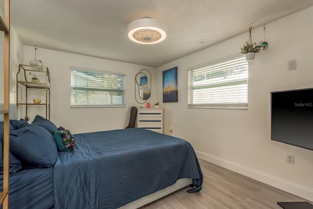 bedroom with hardwood / wood-style floors and a textured ceiling