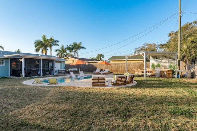 view of yard with a fenced in pool, a sunroom, an outdoor fire pit, and a patio area