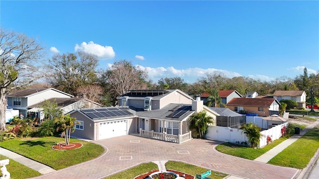 view of front of house featuring fence, a front lawn, a garage, decorative driveway, and a residential view