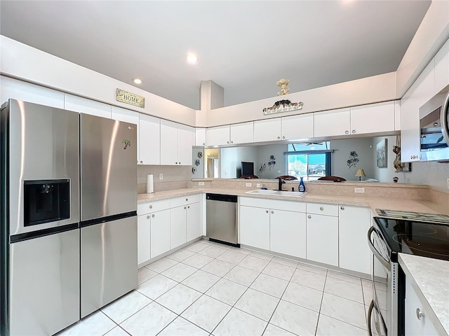 kitchen with light tile patterned flooring, appliances with stainless steel finishes, sink, and white cabinets