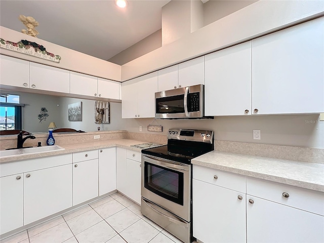 kitchen with white cabinetry, stainless steel appliances, sink, and light tile patterned floors