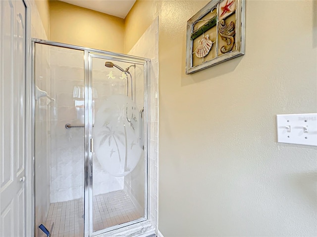 bathroom featuring a shower with shower door