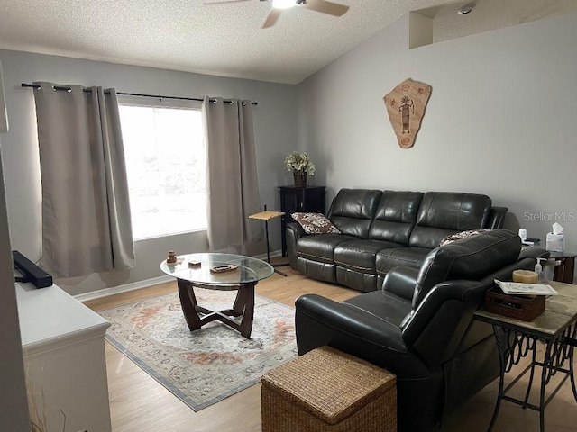 living room featuring ceiling fan, a textured ceiling, and light hardwood / wood-style flooring