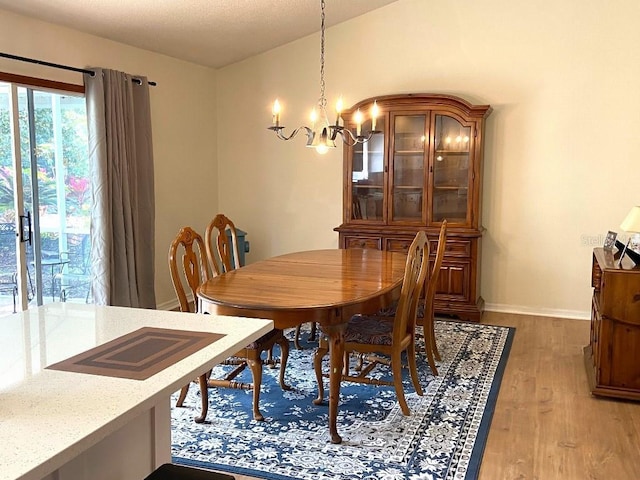 dining space with wood-type flooring and a notable chandelier