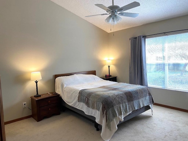 bedroom featuring lofted ceiling, ceiling fan, light carpet, and a textured ceiling