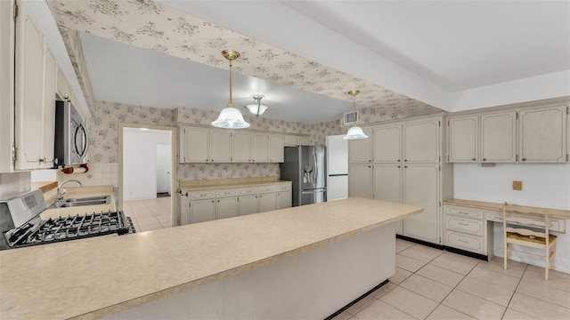 kitchen featuring sink, hanging light fixtures, light tile patterned floors, appliances with stainless steel finishes, and kitchen peninsula