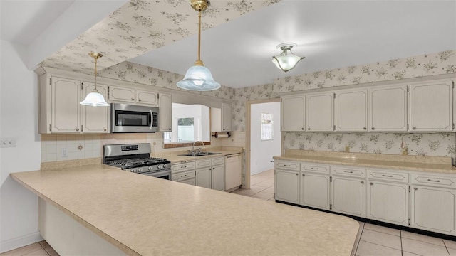 kitchen with pendant lighting, sink, light tile patterned flooring, and appliances with stainless steel finishes