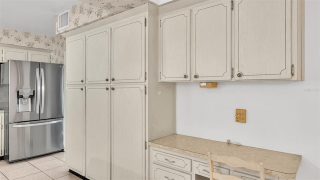 kitchen with light tile patterned floors and stainless steel fridge