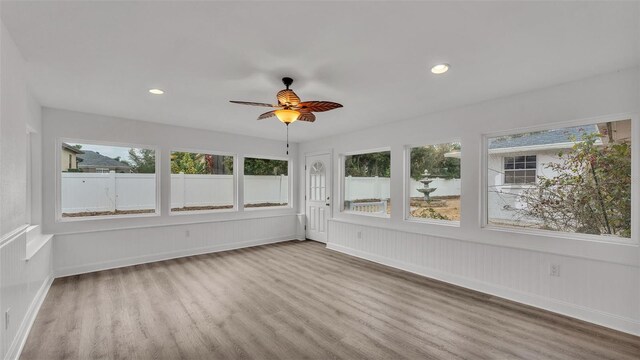 unfurnished sunroom with ceiling fan