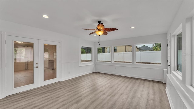 unfurnished sunroom with french doors, ceiling fan, and plenty of natural light