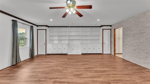 unfurnished bedroom featuring multiple closets, crown molding, and light hardwood / wood-style floors