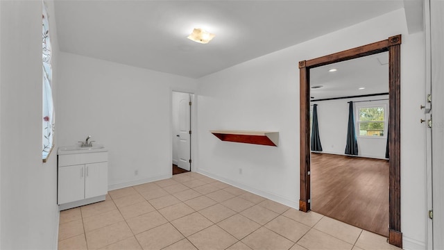 spare room featuring light tile patterned flooring and sink