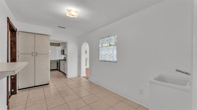 kitchen with stainless steel gas range and light tile patterned flooring