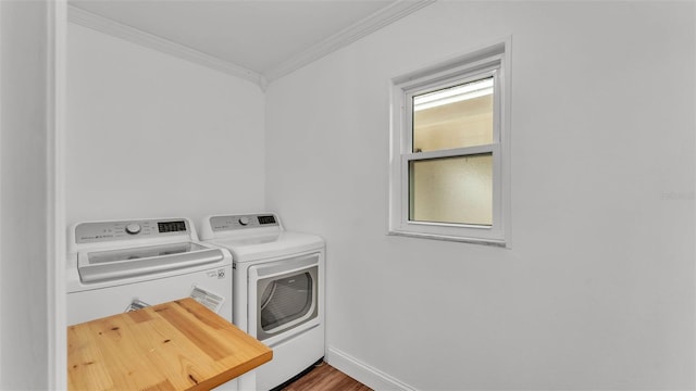 washroom with crown molding, hardwood / wood-style floors, and washer and clothes dryer