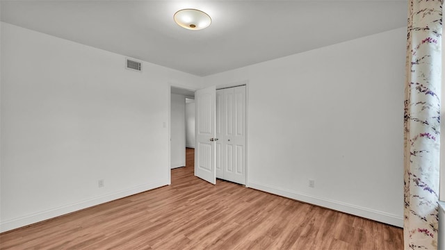 unfurnished bedroom featuring a closet and light hardwood / wood-style flooring