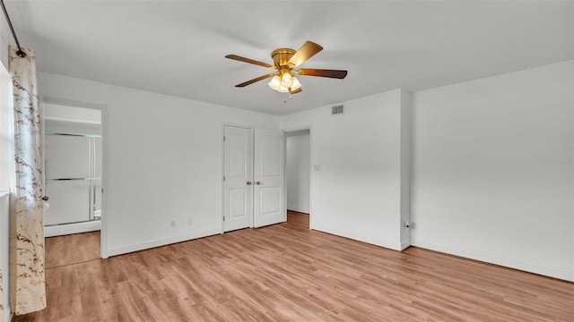 unfurnished bedroom with ensuite bath, ceiling fan, and light wood-type flooring