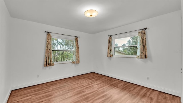 unfurnished room with hardwood / wood-style flooring and a healthy amount of sunlight