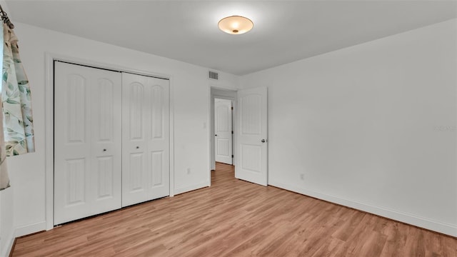 unfurnished bedroom featuring a closet and light wood-type flooring