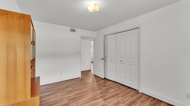 unfurnished bedroom with a closet and light wood-type flooring