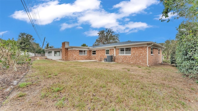 back of house featuring cooling unit and a lawn