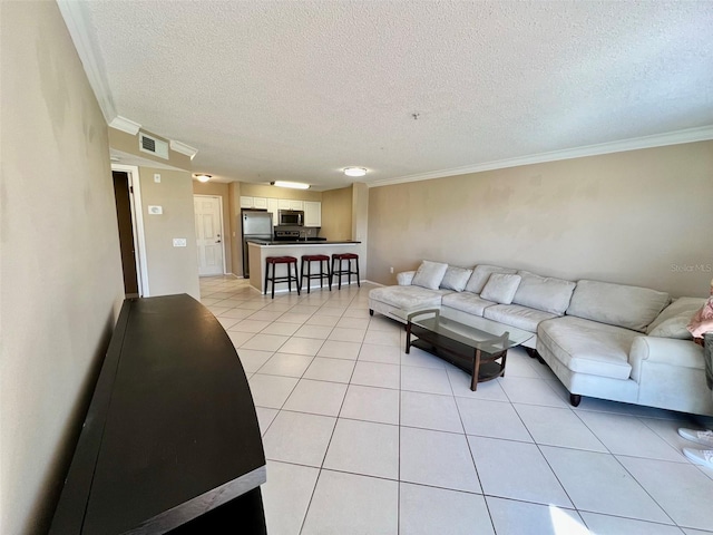 living room featuring light tile patterned flooring, crown molding, and a textured ceiling