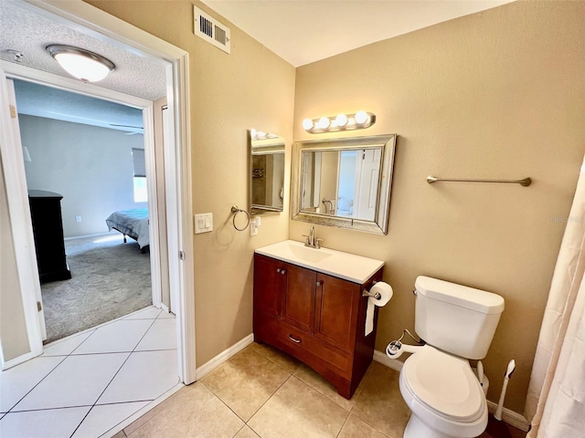 bathroom featuring vanity, tile patterned floors, a textured ceiling, and toilet