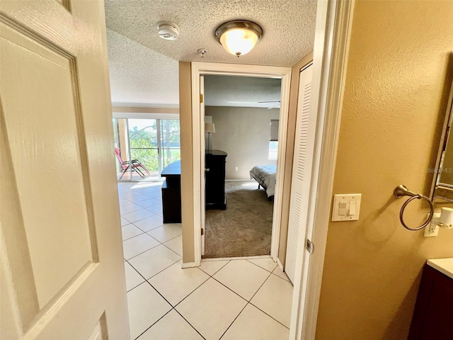 corridor featuring light tile patterned floors and a textured ceiling