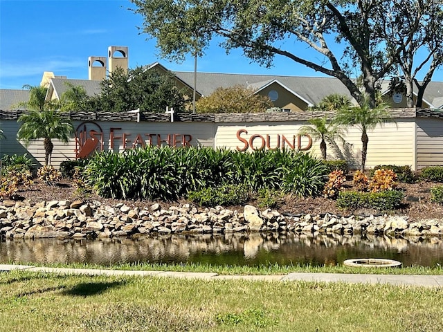 community / neighborhood sign featuring a water view