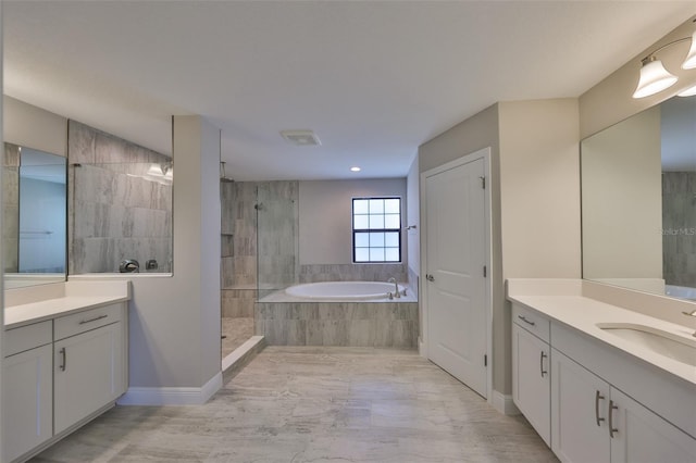 bathroom with two vanities, visible vents, a sink, a walk in shower, and a bath