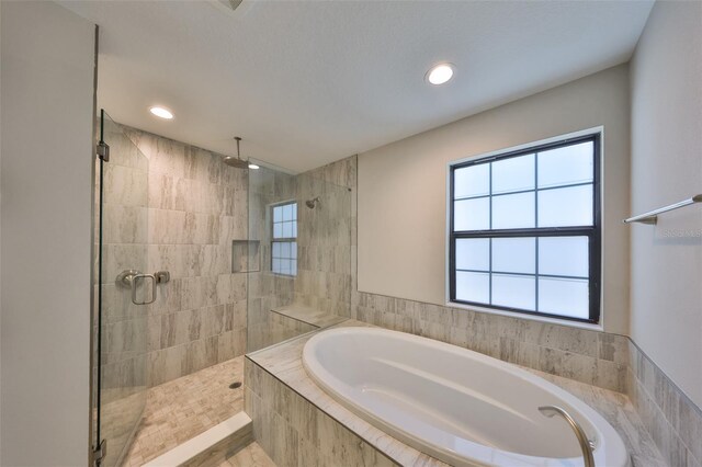 full bathroom with a bath, plenty of natural light, tiled shower, and recessed lighting