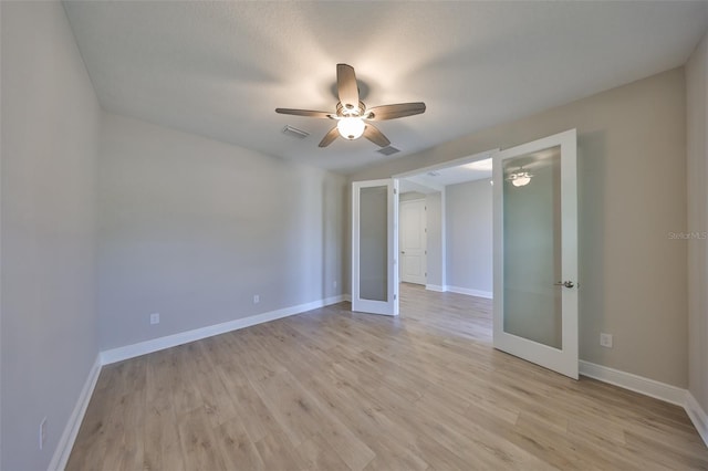 unfurnished room featuring light wood-style flooring, visible vents, baseboards, and french doors