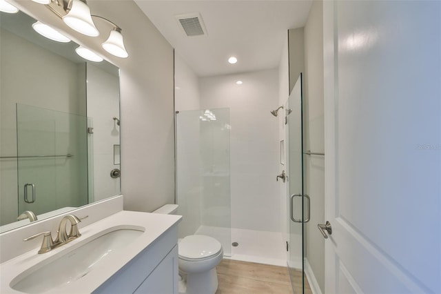 full bath with visible vents, a shower stall, toilet, and wood finished floors