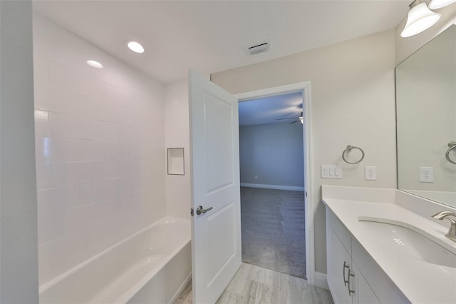 full bathroom with baseboards, wood finished floors, vanity, and recessed lighting