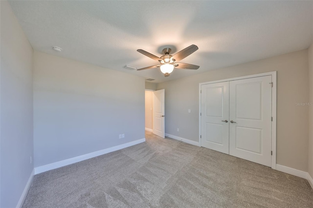 unfurnished bedroom with baseboards, ceiling fan, and light colored carpet