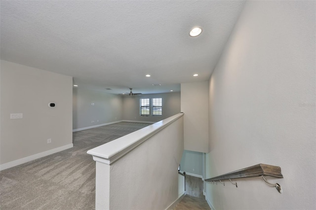 stairs with a textured ceiling, carpet floors, recessed lighting, and baseboards