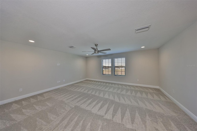 spare room with visible vents, light carpet, and baseboards