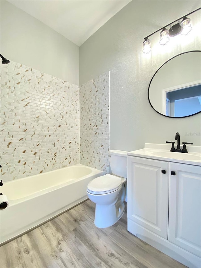 full bathroom with hardwood / wood-style flooring, vanity, shower / bathtub combination, and toilet