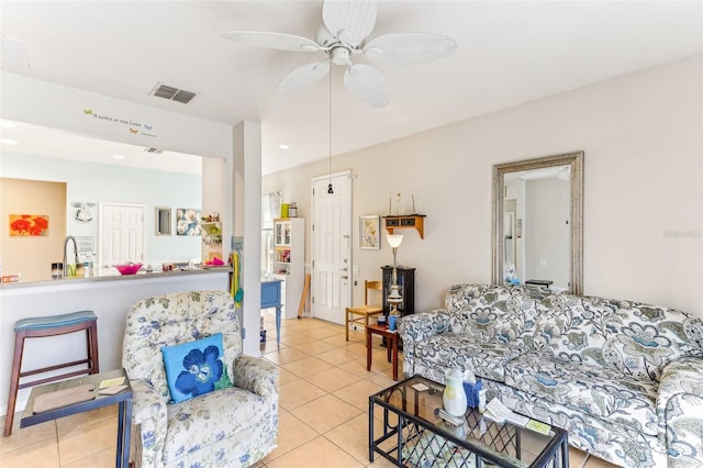 living room featuring light tile patterned flooring, ceiling fan, and sink