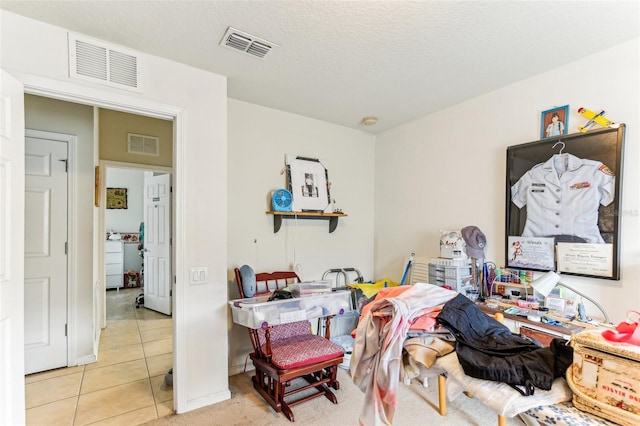 interior space with a textured ceiling and light tile patterned floors