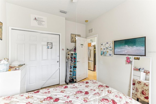 tiled bedroom with stainless steel refrigerator and a closet