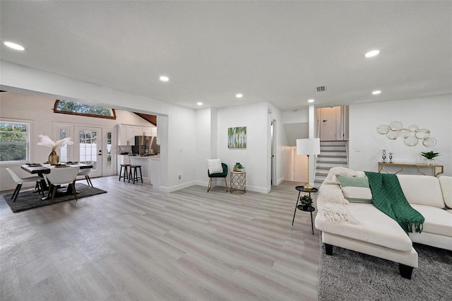 living area featuring baseboards, light wood-style flooring, stairway, french doors, and recessed lighting