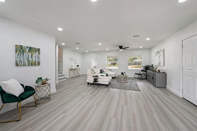 living area with light wood finished floors, baseboards, stairway, and recessed lighting