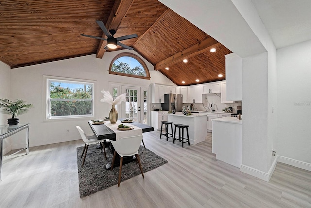 dining room featuring wood ceiling, light wood-style flooring, and beam ceiling